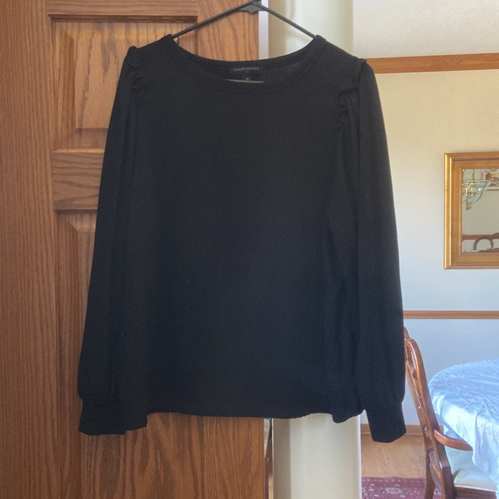 Cute black sweater with slight ruffle details on shoulder and cuffed wrist